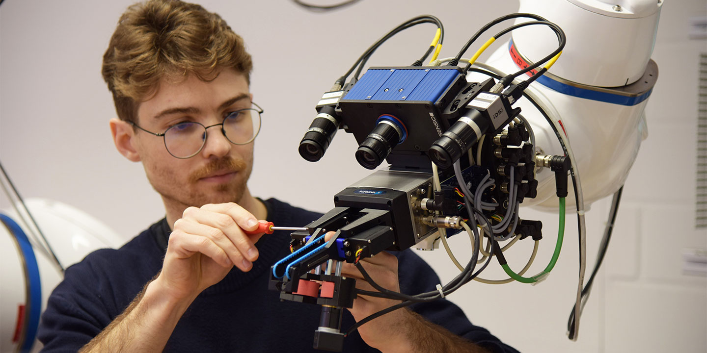 HSLU-Forscher Tobias Banz schraubt an seinem robotischen Handlanger.