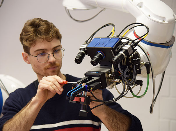 HSLU-Forscher Tobias Banz schraubt an seinem robotischen Handlanger.