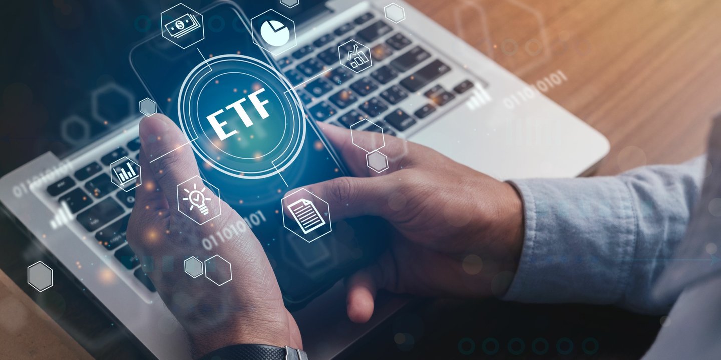 Hände mit Smartphone mit ETF-Schriftzug Hände mit Smartphone mit ETF-Schriftzug