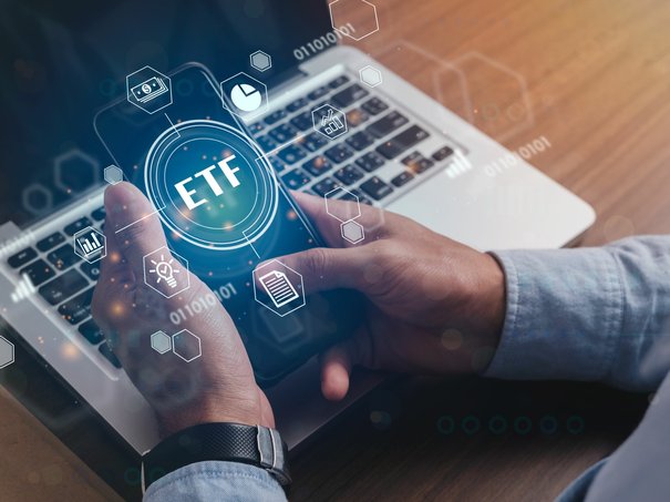Hände mit Smartphone mit ETF-Schriftzug Hände mit Smartphone mit ETF-Schriftzug