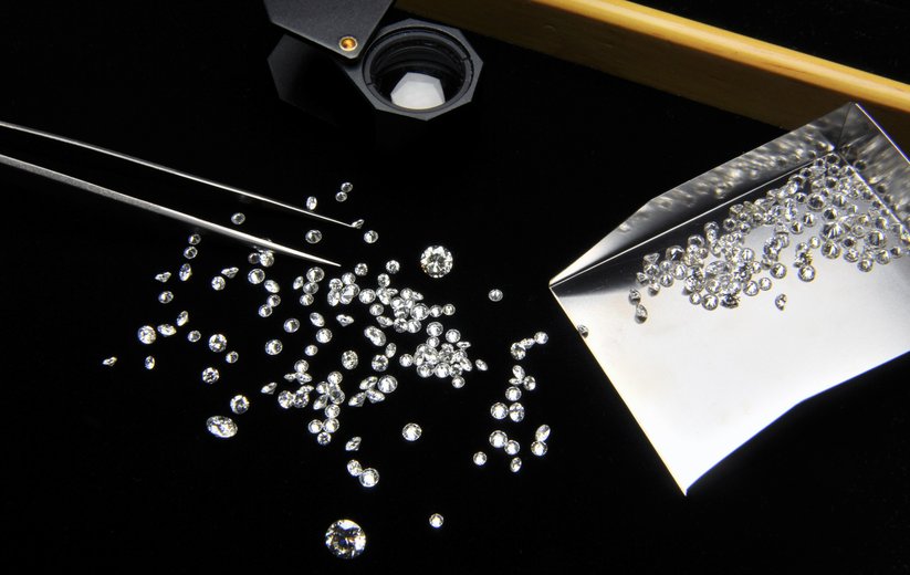 Diamanten mit Pinzette und Schüttgutbehälter