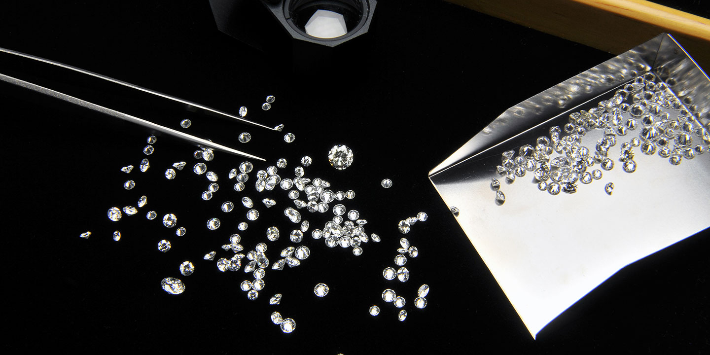 Diamanten mit Pinzette und Schüttgutbehälter