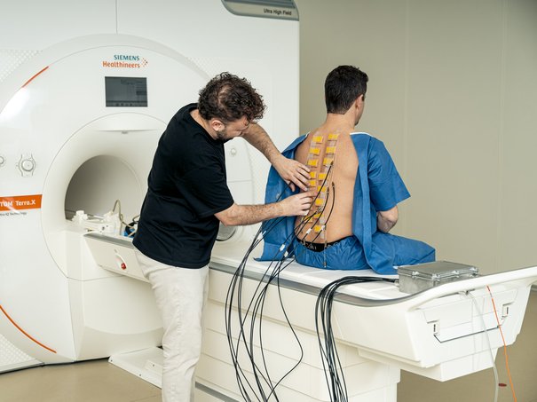 HSLU-Forscher Louis Schibli bringt Stimulationsgeräte am Rücken an.