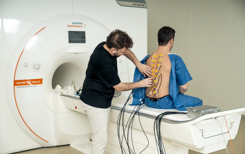 HSLU-Forscher Louis Schibli bringt Stimulationsgeräte am Rücken an.